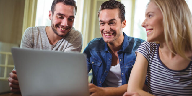 Die neue Webseite ist live, 3 Freunde freuen sich darüber vor dem Laptop